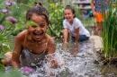 Two children splash in a flooded garden